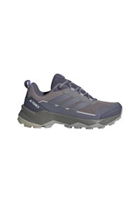 Scarpa da trekking grigia con tomaia in mesh, suola in gomma e dettagli testurizzati. Presenta un sistema di allacciatura e le tre strisce distintive sul lato.