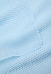 Hellblaues Material mit einer zerknitterten Textur, das einen glatten Rand und feine Nähte aufweist. Das Design ist weich und leicht.