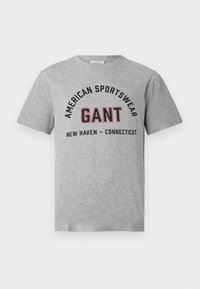 Grå T-skjorte med kort erm og trykket "American Sportswear GANT New Haven - Connecticut" foran i svarte og røde bokstaver.