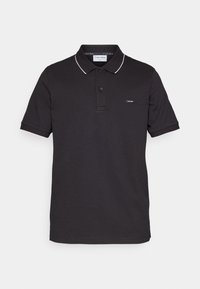 Polo à manches courtes noir avec bordure blanche sur le col et les bords des manches, patte de boutonnage à deux boutons, et petit logo Calvin Klein sur la poitrine.