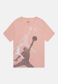 Camiseta de algodón rosa con un estampado gráfico de jugadores de baloncesto en blanco y plata brillante en el frente, cuello redondo y mangas cortas.
