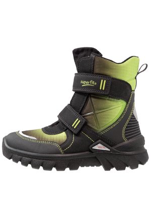 Botte d'hiver montante pour enfant en noir et vert avec deux bandes Velcro, semelle robuste et languette à l'arrière.