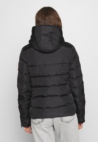 Black puffer jacket with a hood and quilted design, featuring vertical stitching and elastic cuffs. Light, water-resistant material.