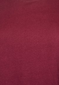 Burgundska bombažna majica z okrolim izrezom in gladko teksturo, s minimalnim šivanjem ter brez vidnih vzorcev ali poudarkov.