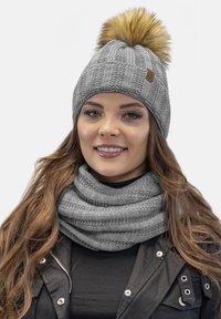 Căciulă gri tricotată cu un pom-pom din blană sintetică, având o textură în relief. Asortată cu o eșarf�ă gri texturată.