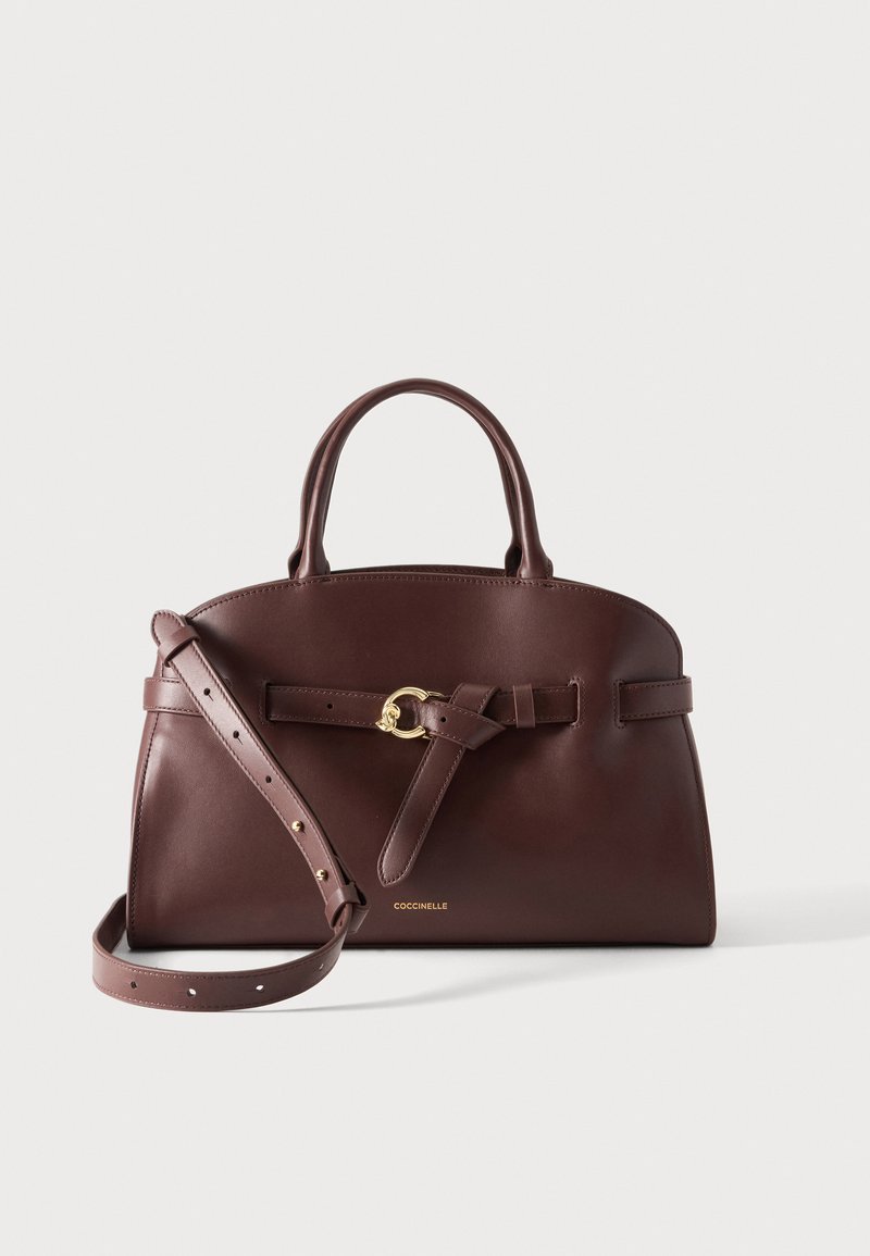 Sac à main en cuir marron foncé avec poignées supérieures, bandoulière réglable et détail de boucle dorée sur la ceinture avant.