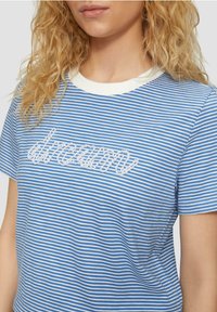 Blauw-witte gestreepte t-shirt met korte mouwen en een ronde hals. Bevat geborduurde "droom" tekst in het wit. Katoenmix stof.