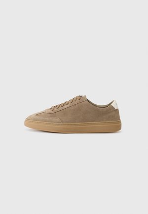 Suede sneakers in light brown with a rubber sole. Features lace-up design and a minimalistic style, accented by a white heel tab.