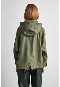 Olivgrön vattentät jacka med huva, lös passform och ventilerad ryggdetalj. Har subtila sömmar och inga synliga stängningar eller mönster.