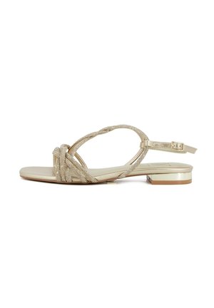 Sandalo beige piatto con tacco basso metallico, cinturini annodati con strass sulle dita e cinturino regolabile con fibbia alla caviglia.