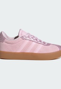 Pink suede sneaker with metallic accents, three lateral stripes, and a gum rubber sole. Features textured detail at the heel and laces.