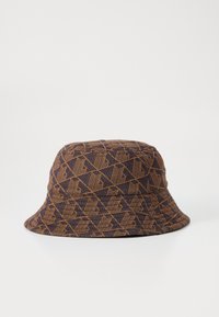 Buckethatt i mørk lilla stoff med et geometrisk brunt mønster. Myk tekstur, bred brem, og strukturert form.