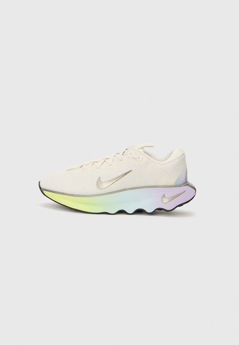 Zapatilla de correr Nike con una parte superior de malla color crema, acentos plateados y una suela en degradado multicolor con un diseño ondulado.