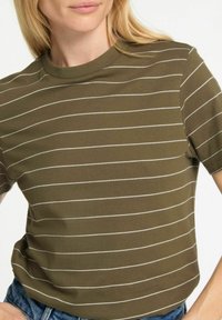 T-shirt verde oliva a maniche corte con strisce orizzontali bianche, caratterizzato da un classico collo a giro e una morbida trama di cotone.