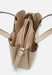 Beiger Handtasche mit goldfarbenen Beschlägen, zwei Innenfächern und schwarzen Akzenten. Verfügt über einen Reißverschluss und verstellbare Träger. Glatte Textur.