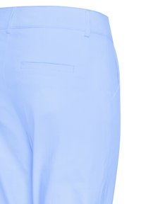 Pantalon bleu clair avec passants pour ceinture et une poche arrière passepoilée, vu de la taille jusqu'au milieu de la cuisse.