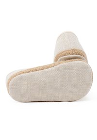 Pantofola in tela con tomaia beige e rifiniture in juta intrecciata. Caratterizzata da una superficie texture e una suola piatta e flessibile color beige chiaro.