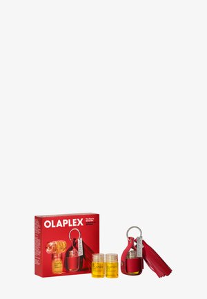 Caja roja de Olaplex con dos pequeños frascos de aceite de enlace y un llavero rojo con un adorno de borla y una botella adjunta.