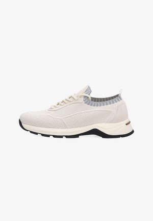 Lichtbeige atletische schoen met een bovenwerk van gebreid mesh, veters aan de voorkant, gevoerde kraag en dikke zwarte en witte zool, getoond in zijaanzicht.