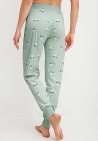 Lichtgroene pyjamabroek met een witte ijsbeerprint, voorzien van een zachte elastische tailleband en fitted boorden bij de enkels.