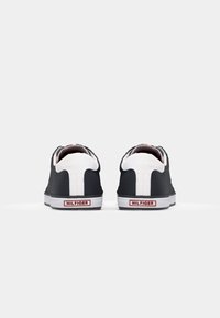 Zwart-witte sneakers met een glad bovenwerk, witte rubberen zool, logodetail op de hiel en een contrasterende hieltab.