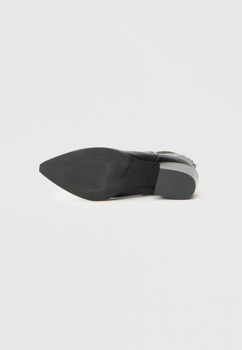 Schwarzer Knöchelstiefel mit spitzem Zehenbereich, strukturiertem Lederoberteil und niedrigem Absatz. Verfügt über eine glatte, langlebige Sohle mit dezenten Profilmustern.