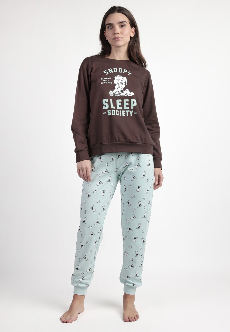 Sudadera marrón con gráfico de Snoopy y texto "Sleep Society". Pantalones de pijama azul claro con diseño impreso de Snoopy, tobillos ajustados y tejido suave.
