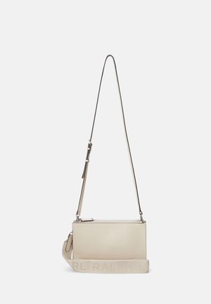Beige rektangulær crossbody-taske med justerbar tynd rem og bredt stof skulderrem præget med teksten "RALPH LAUREN".