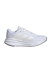 Chaussure de course athlétique blanche avec dessus en mesh, trois bandes beiges sur le côté, semelle amortissante et semelle extérieure noire.