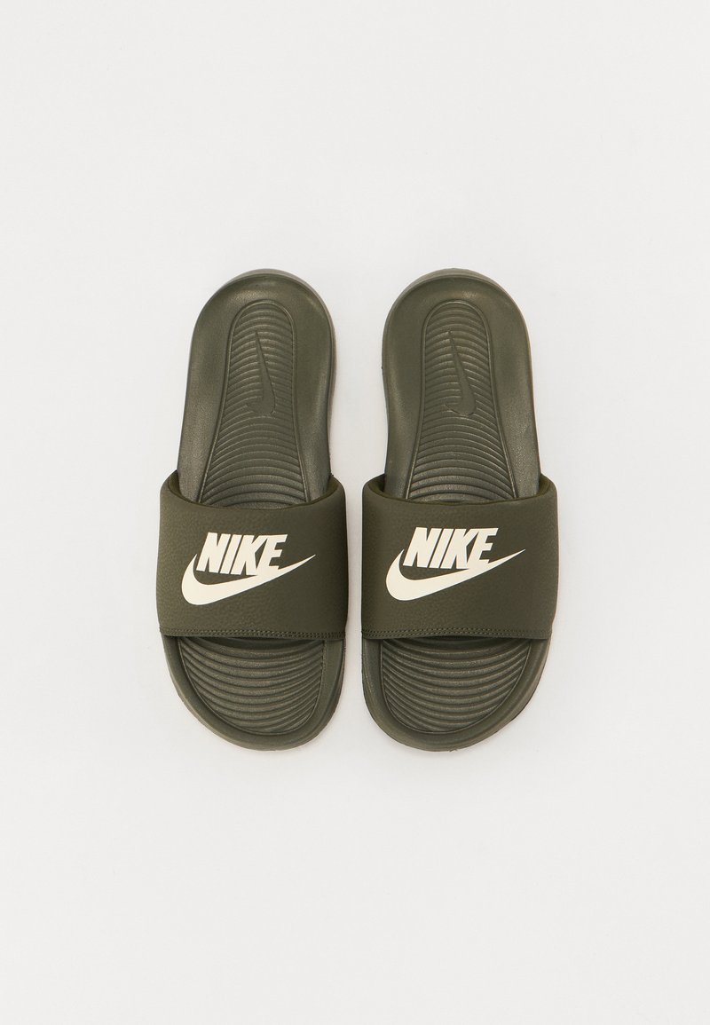 Chanclas de goma verdes con una suela texturizada, que presentan una correa ancha con un logo de Nike en blanco.