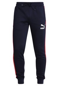 Marineblauwe joggingsbroek met rode zijstrepen, elastische tailleband, verstelbaar trekkoord en wit Puma-logo op het linkerbeen.