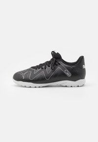 Sneakers neri con punta testurizzata, design a zigzag grigio chiaro, lacci neri e suola bianca con piccoli tacchetti antiscivolo.