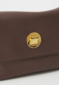 Brown leather clutch with a textured surface, featuring a shiny gold-toned snap closure and subtle branding on the hardware.