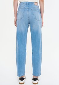 Jeans de mezclilla azul claro con un corte recto, que presentan una cinturilla alta, dos bolsillos traseros y un cinturón cosido. Textura sólida, sin patrones visibles.