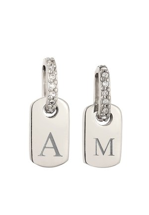 Boucles d'oreilles créoles argentées avec petits cristaux et pendentifs argentés rectangulaires gravés des lettres "A" et "M" sur fond blanc.