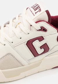 Sneaker mit cremefarbenem Lederobermaterial, kastanienbraunen Akzenten und Gummisohle. Verfügt über eine strukturierte Wildlederpaneel, einen bedruckten Logo auf der Zunge und flache Schnürsenkel.