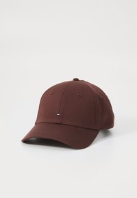 Brown baseball cap made of fabric with a curved brim. Features subtle stitching and a small embroidered logo on the front.
