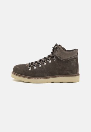 Zapatos de senderismo de ante marrón con ojales de metal, cordones negros y una suela de goma ligera. Presentan un collarín acolchado para mayor soporte.