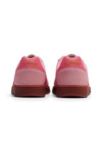 Ténis de desporto cor-de-rosa com parte superior em camurça e malha. Apresenta um logo dourado, colarinho acolchoado e uma sola de borracha texturizada.