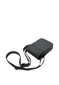 Svart axelväska i texturerat material, med rektangulär form, justerbar rem och en jämn, matt yta.