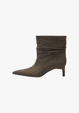 Bottine en daim marron à bout pointu et petit talon kitten, avec un design supérieur ample et plissé.