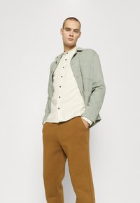 Jack & Jones JJIKANE JJBRINK PANTS - Calças de fato de treino - desert palm