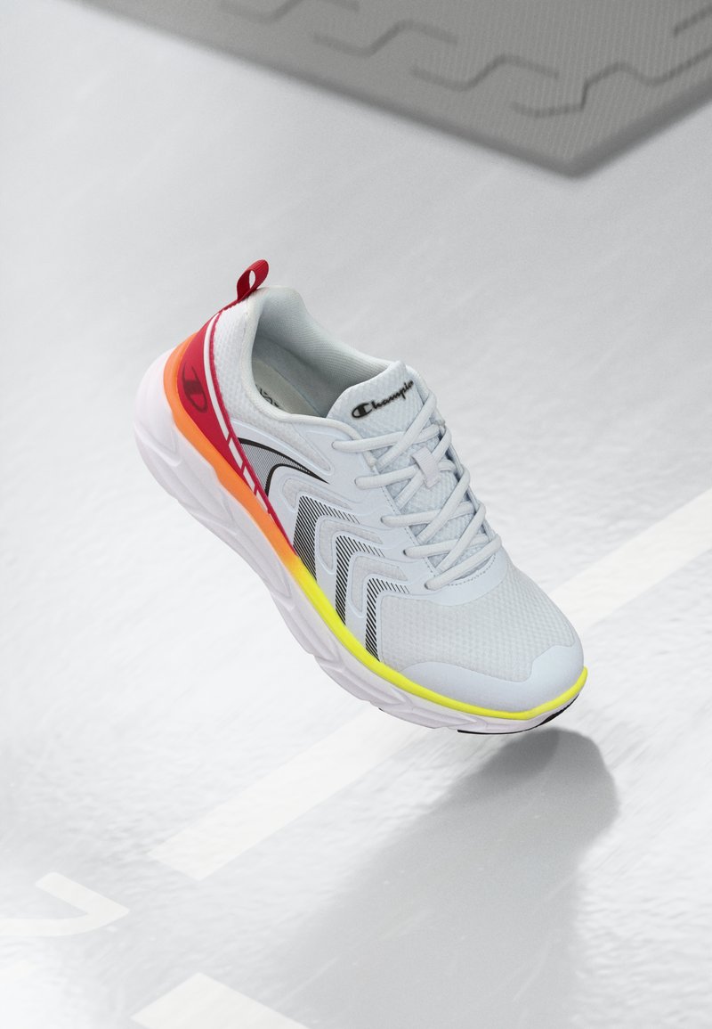 Lightweight grey athletic shoe with a mesh upper, red and yellow accents, and black detailing. Features a textured sole and cushioning.