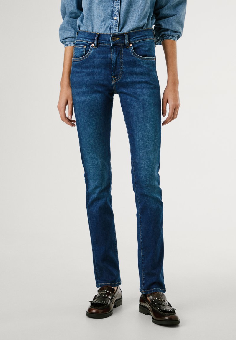Tynne jeans i mørk blå denim med en tettsittende design, med stikning i lommene, kobberfarget detaljer og en jevn tekstur.