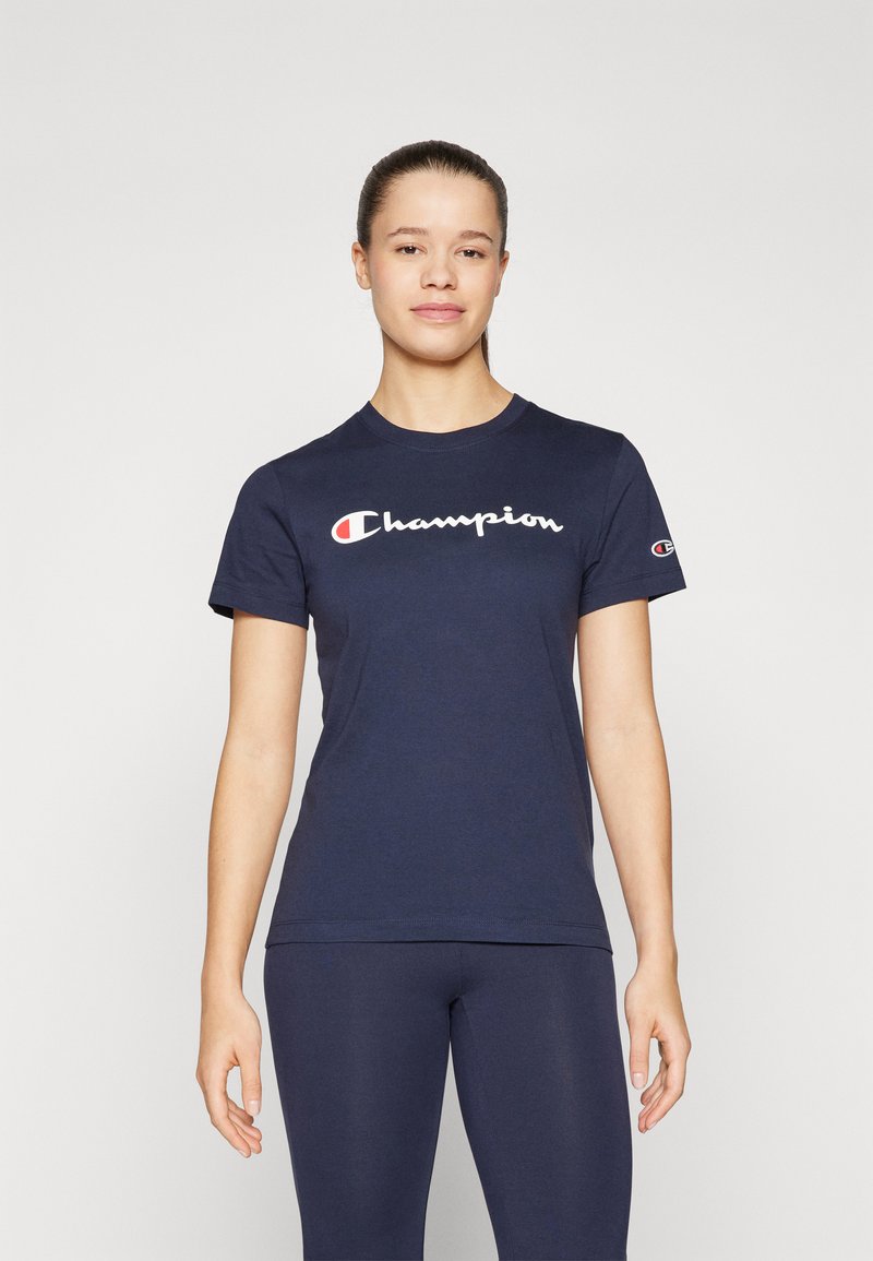 Námornícky bavlnený tričko s bielym logom "Champion" na hrudi a malým logom na ľavom rukáve. Krátke rukávy a okrúhly výstrih.