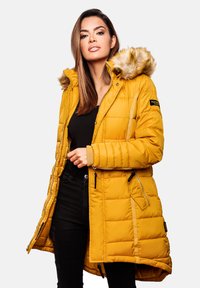 Yellow puffer coat with a fur-trimmed hood, featuring a zip closure, side pockets, and quilted texture. Accents include a logo patch.