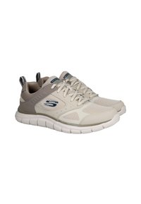 Zapatillas deportivas de color beige claro con paneles de malla, suela acolchada, acentos grises y un logo azul en la lengüeta. Cuenta con tiras en la parte trasera para facilitar su colocación.