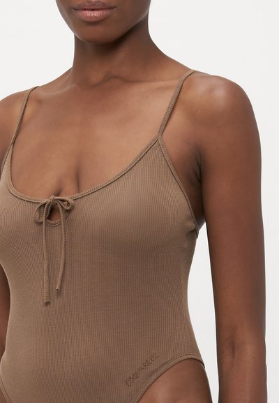Maillot de bain une pièce marron à rayures avec bretelles réglables, un détail de nœud sur le devant et un accent logo sur le côté. Texture lisse et design simple.