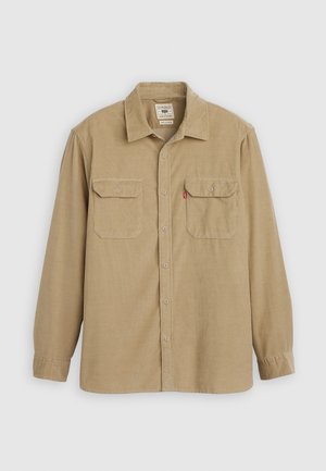 Chemise à boutons beige en tissu texturé, avec un col, deux poches poitrine et des manches longues avec des poignets à boutons.
