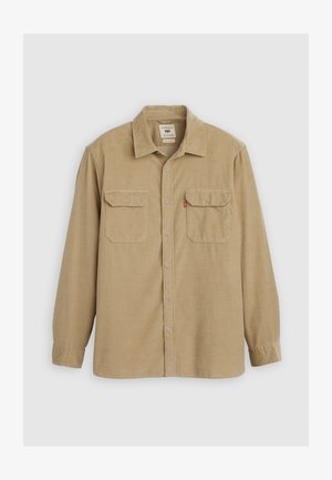 Tan button-up shirt made of textured fabric, featuring a collar, two chest pockets, and long sleeves with button cuffs.